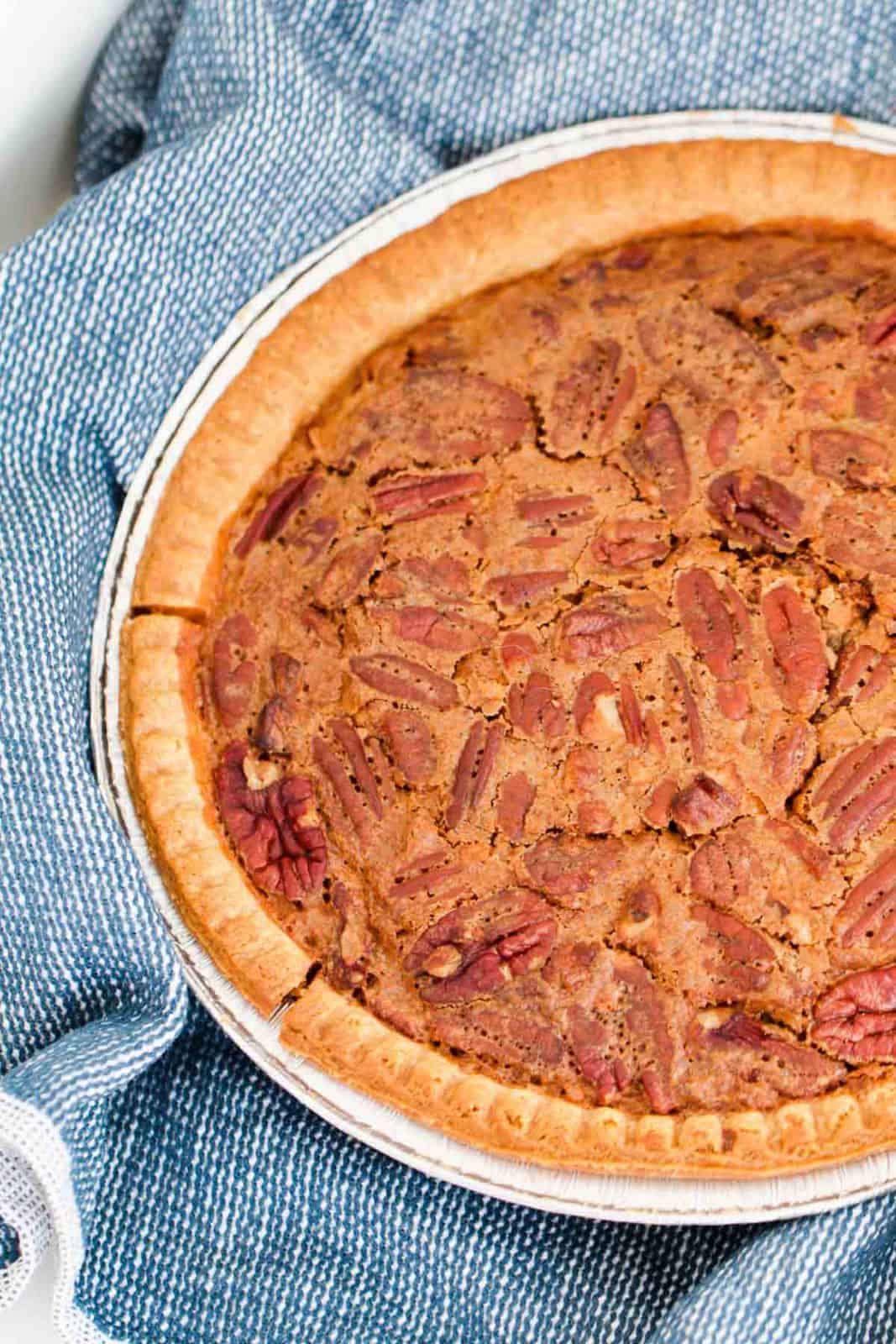 A baked pecan pie in a shortcrust pastry tart shell.