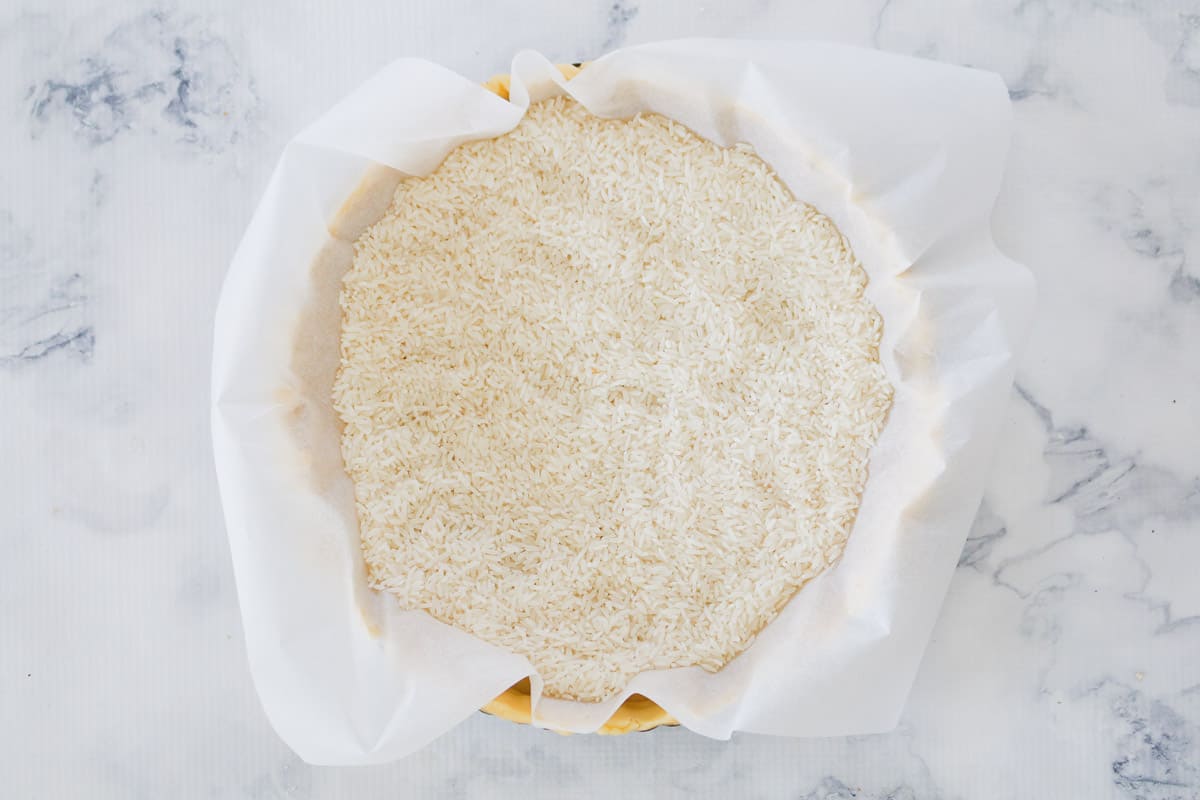 Rice on top of baking paper in a round tart tin.