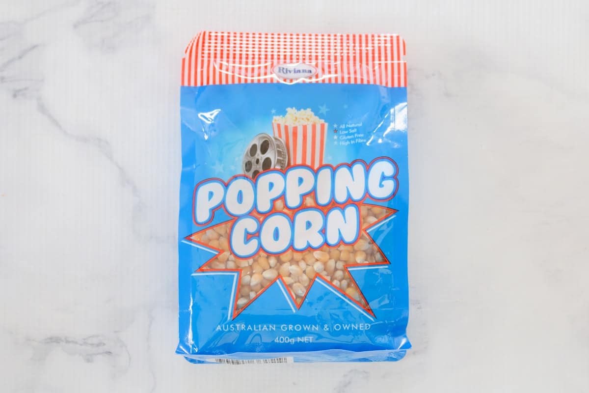 A blue, white and red bag of popcorn kernals.