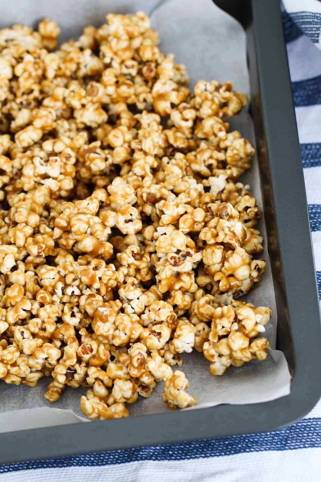 Salted caramel popcorn on a tray lined with baking paper