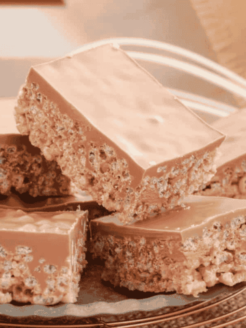 Pieces of Mars Bar slice with chocolate on top stacked together.