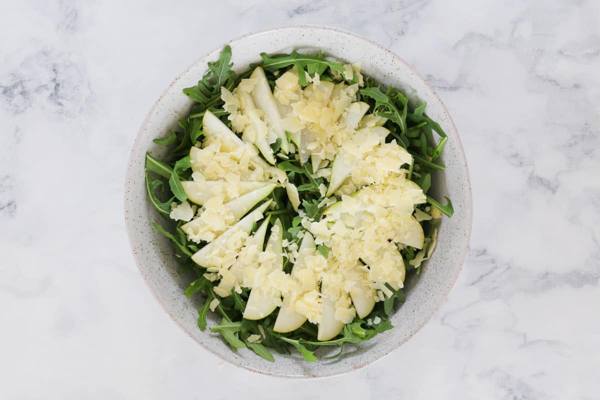 Pear, parmesan and rocket in a bowl.