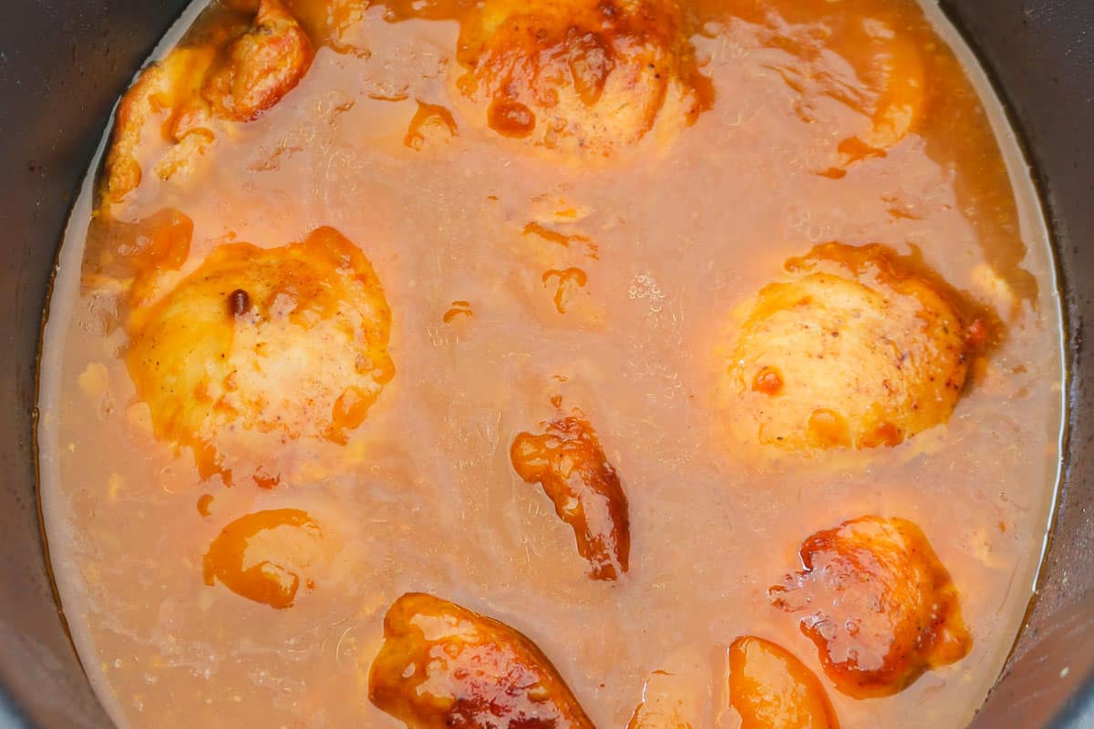 Chicken cooked in an apricot sauce in a slow cooker.