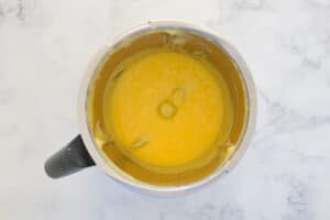 A Thermomix bowl filled with creamy yellow lemon curd.