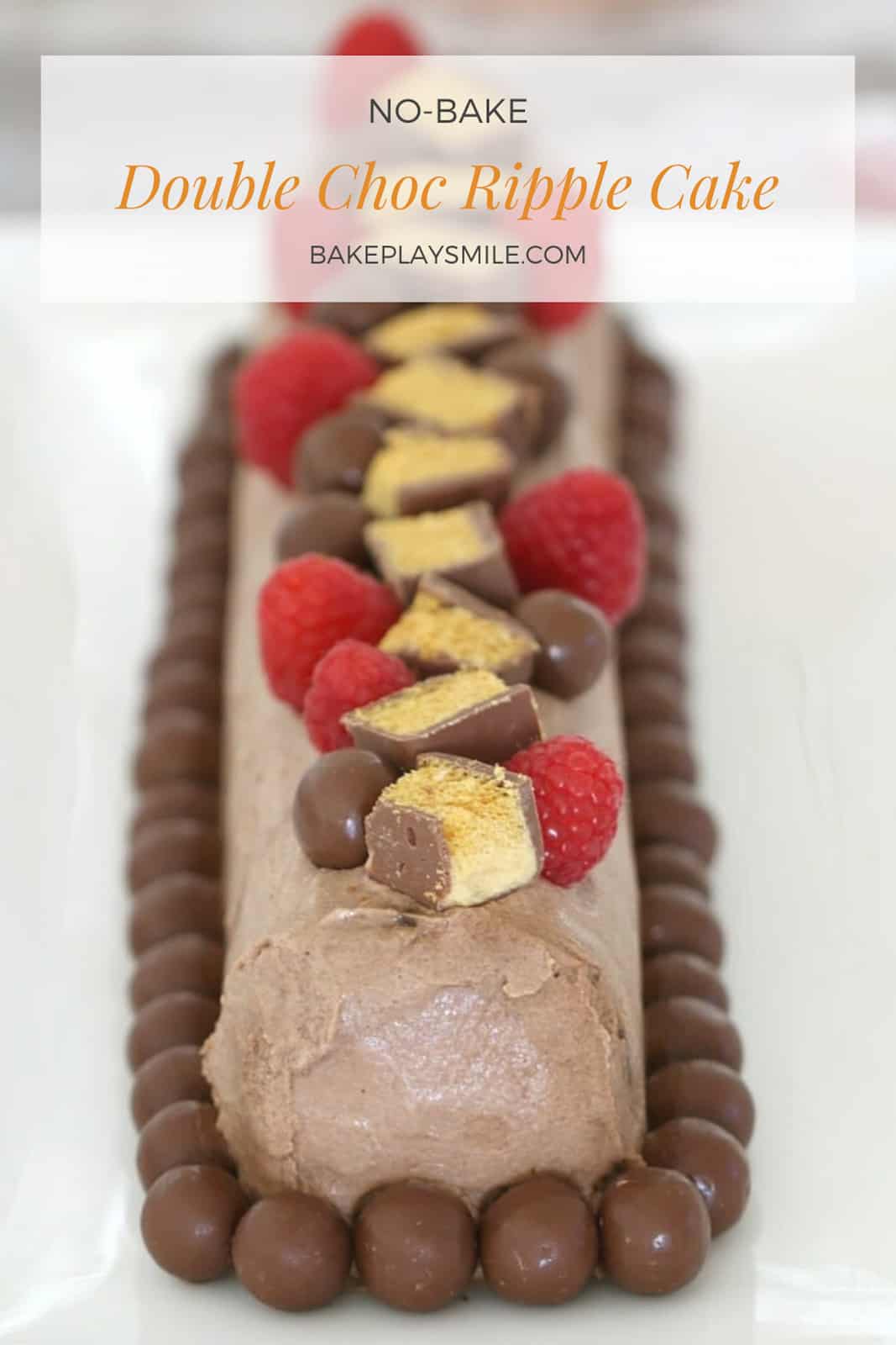 A rectangular log of chocolate ripple cake decorated with chocolate whipped cream, raspberries and chocolates.