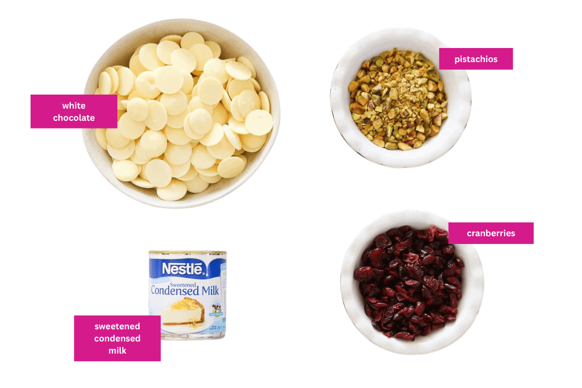Bowls filled with white chocolate, pistachios and cranberries next to a can of sweetened condensed milk.
