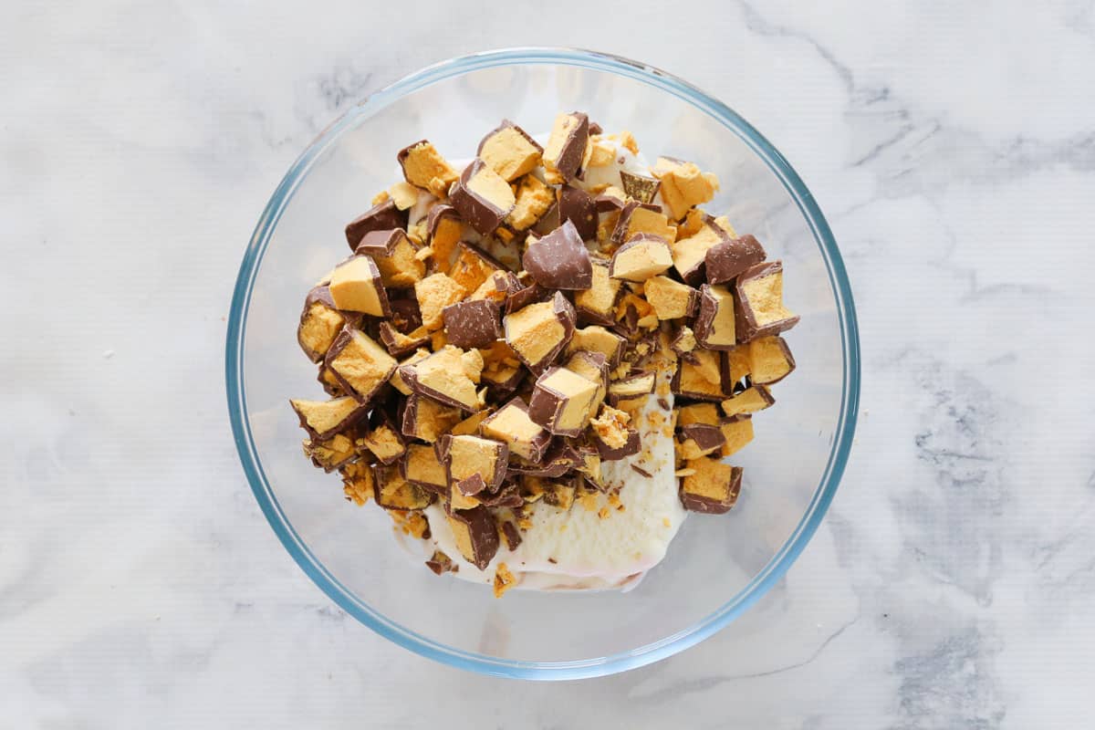 A bowl of vanilla ice-cream with chunks of honeycomb on top.