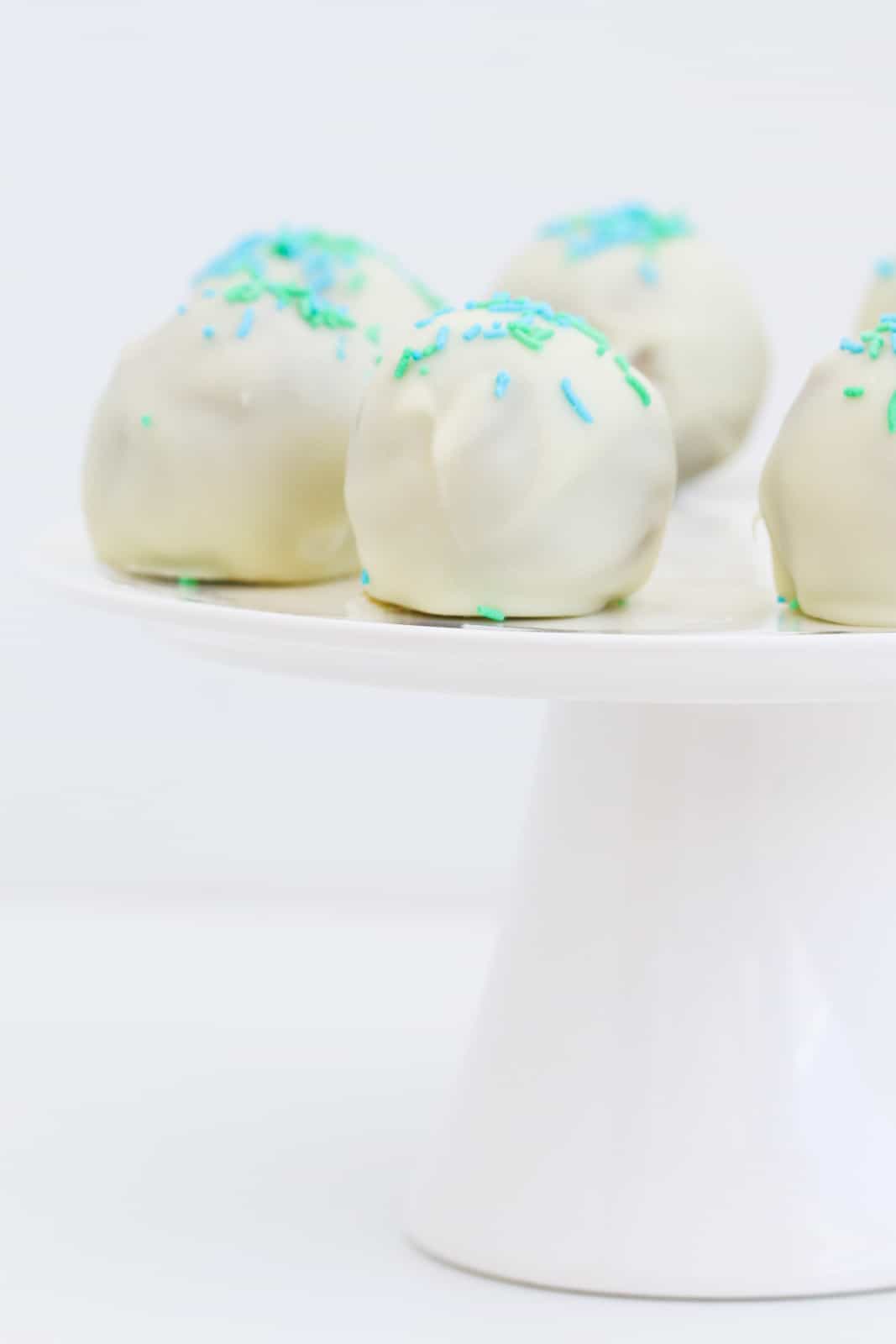 A close up of Peppermint Crisp Tim Tam balls with green sprinkles.