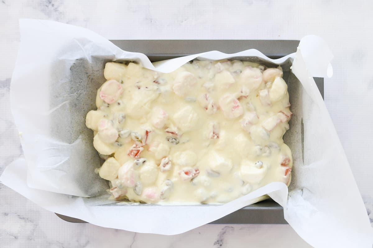 White rocky road spread on baking paper in a baking tray.