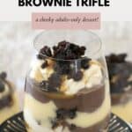 A layered custard trifle in individual glasses with crumbled brownie on top.
