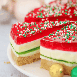 A Christmas themed jelly cake with a slice being removed.
