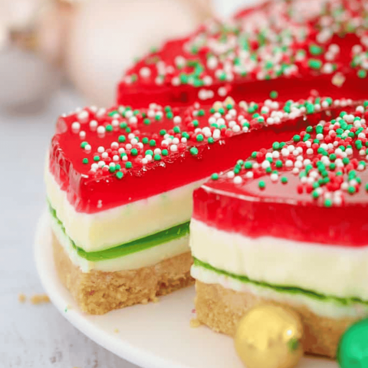 A Christmas themed jelly cake with a slice being removed.