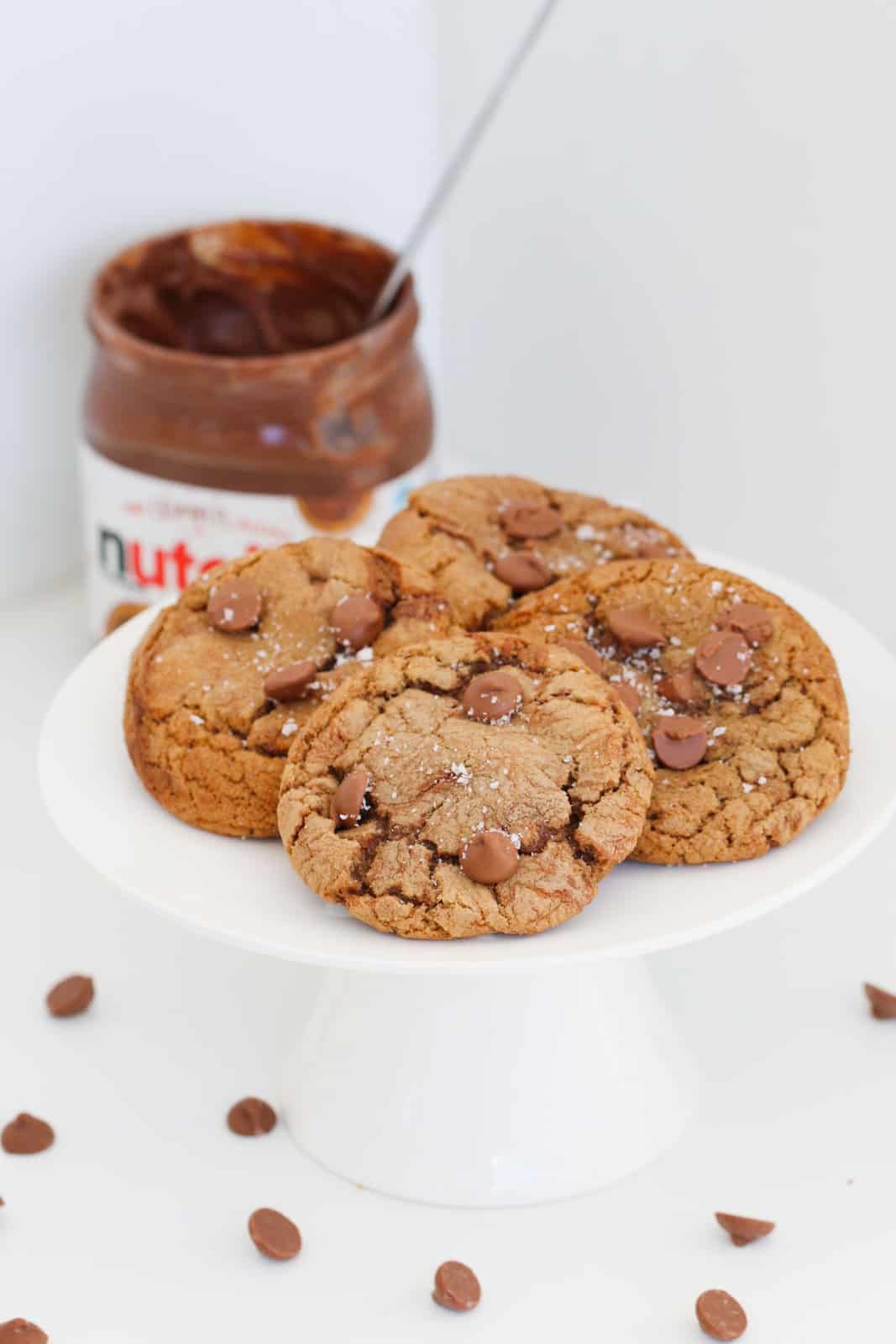 4 cookies served on a white cake stand with a jar of Nutella in the background.