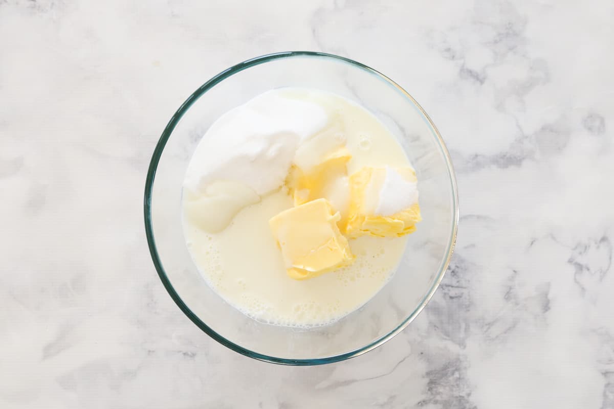 Butter, sugar, and milk in a glass mixing bowl