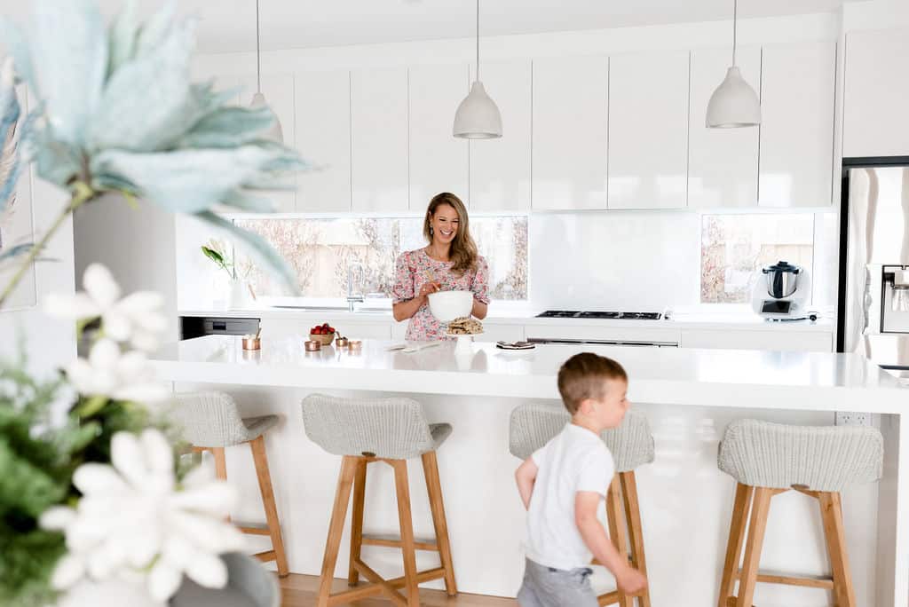 A mum and her son in a white kitchen.