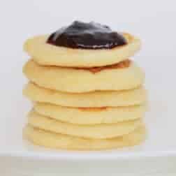A stack of pikelets on a white plate.