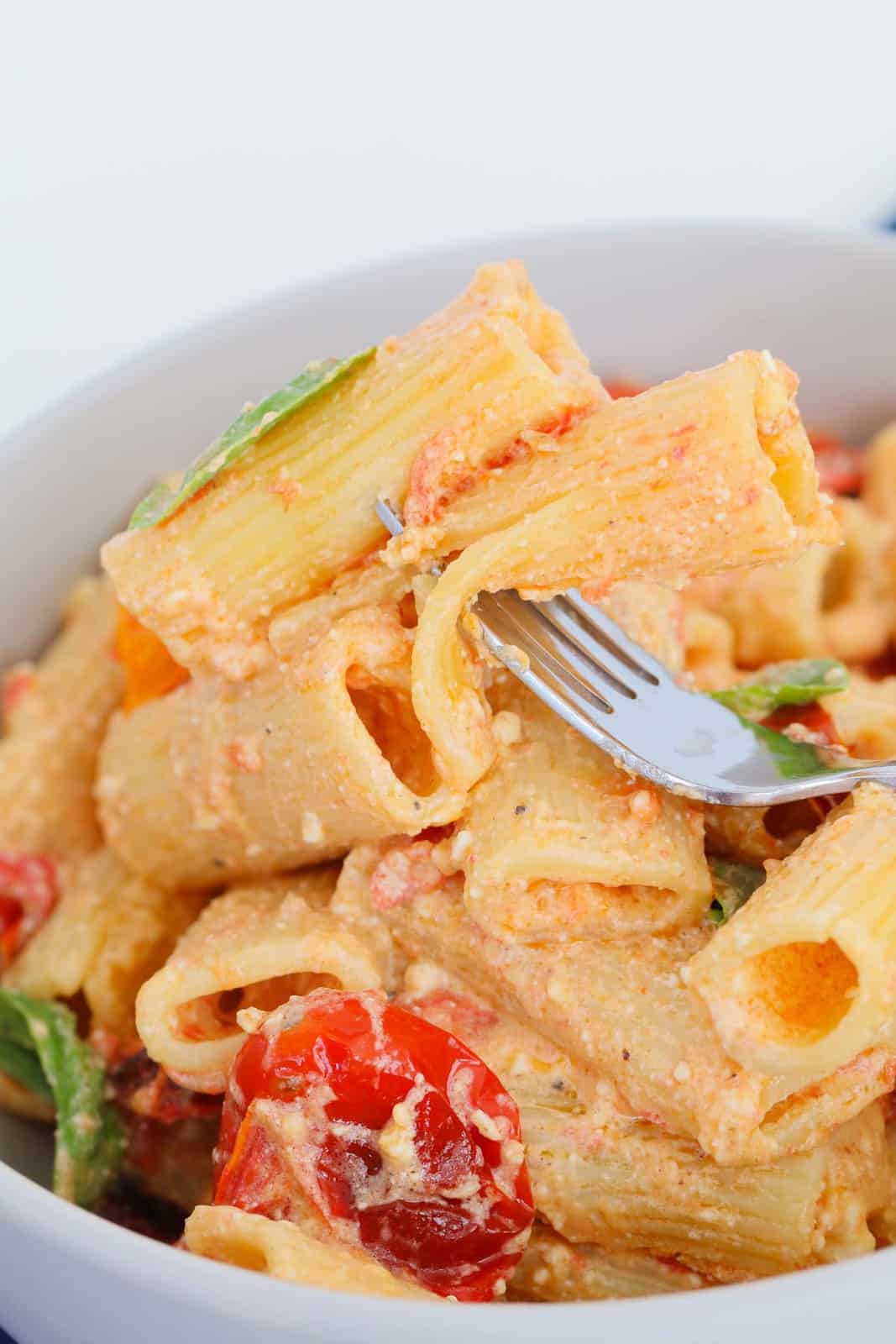 A bowl of Tik Tok tomato & feta pasta with a forkful of pasta.