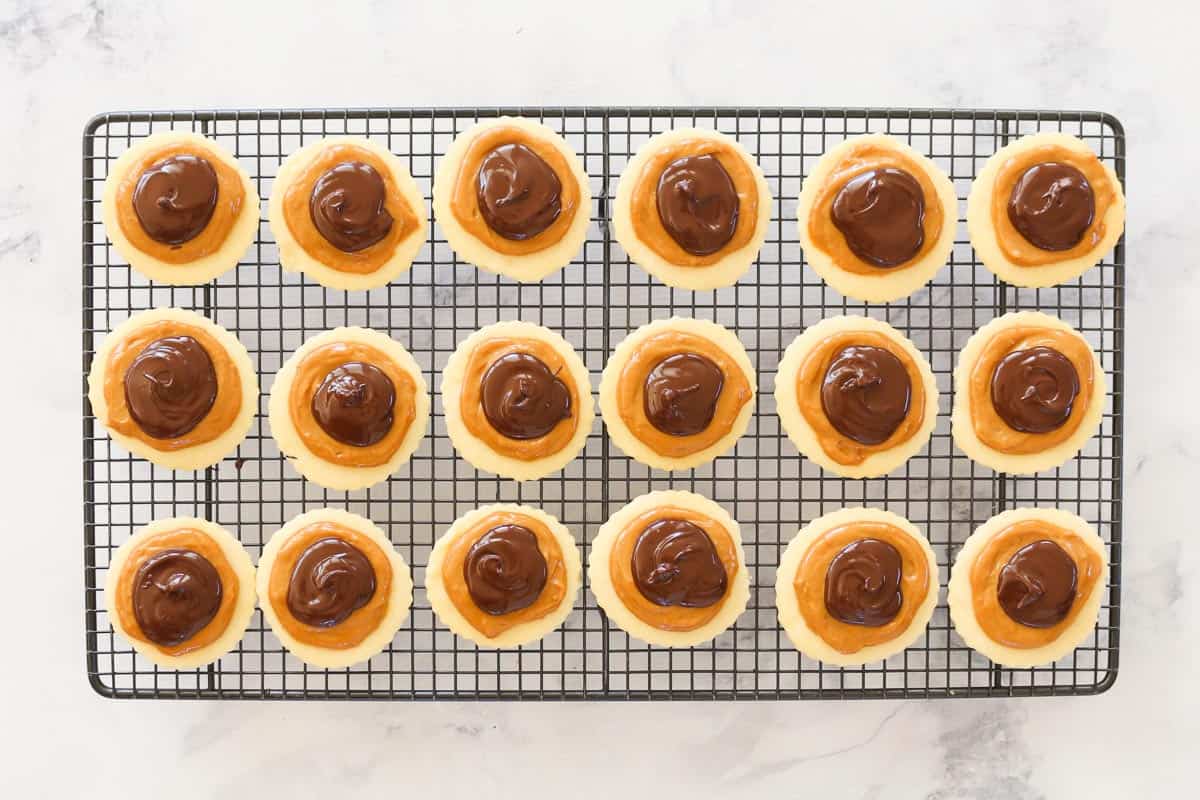 Chocolate and caramel layered on top of round shortbread cookies