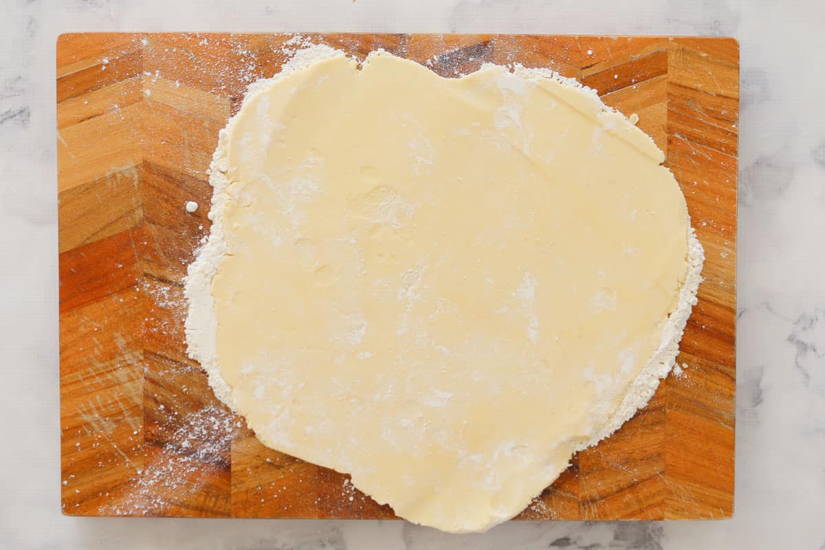 Kneaded and rolled out dough on a wooden board