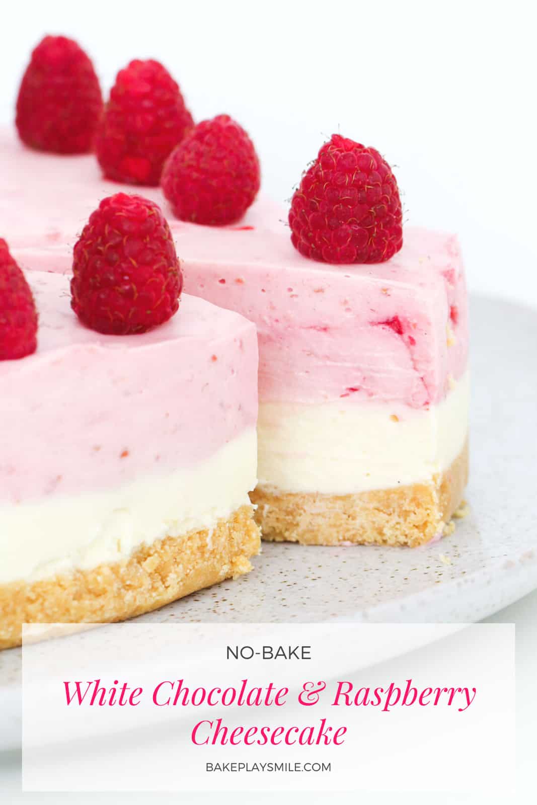 close up shot of cheesecake with white and pink layers garnished with fresh berries