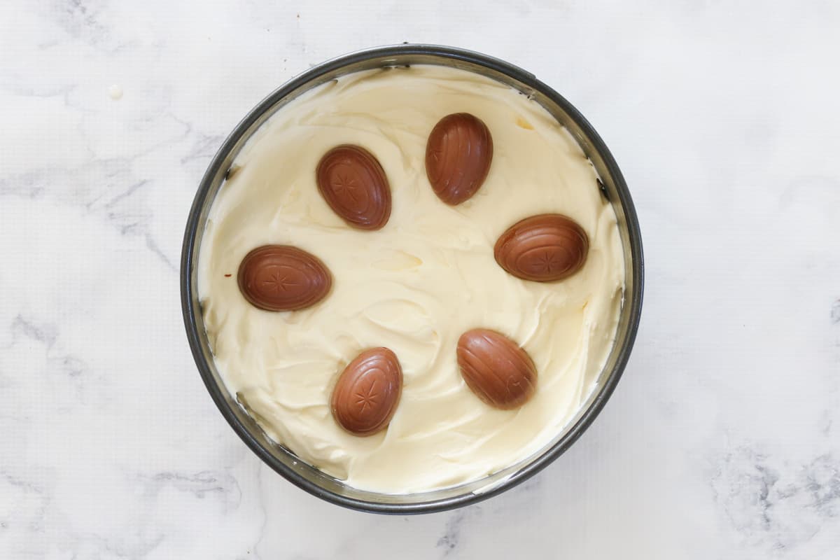 Creme Eggs on top of a white chocolate cheesecake mixture.