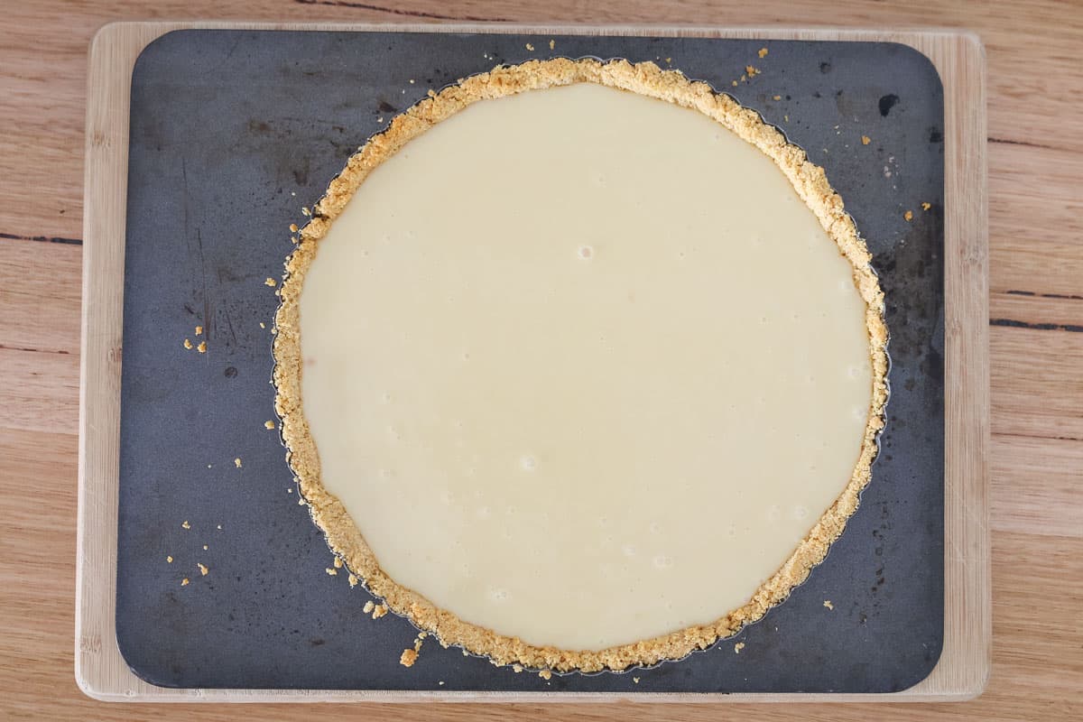 Caramel filling in a tart tin with a cookie crust.