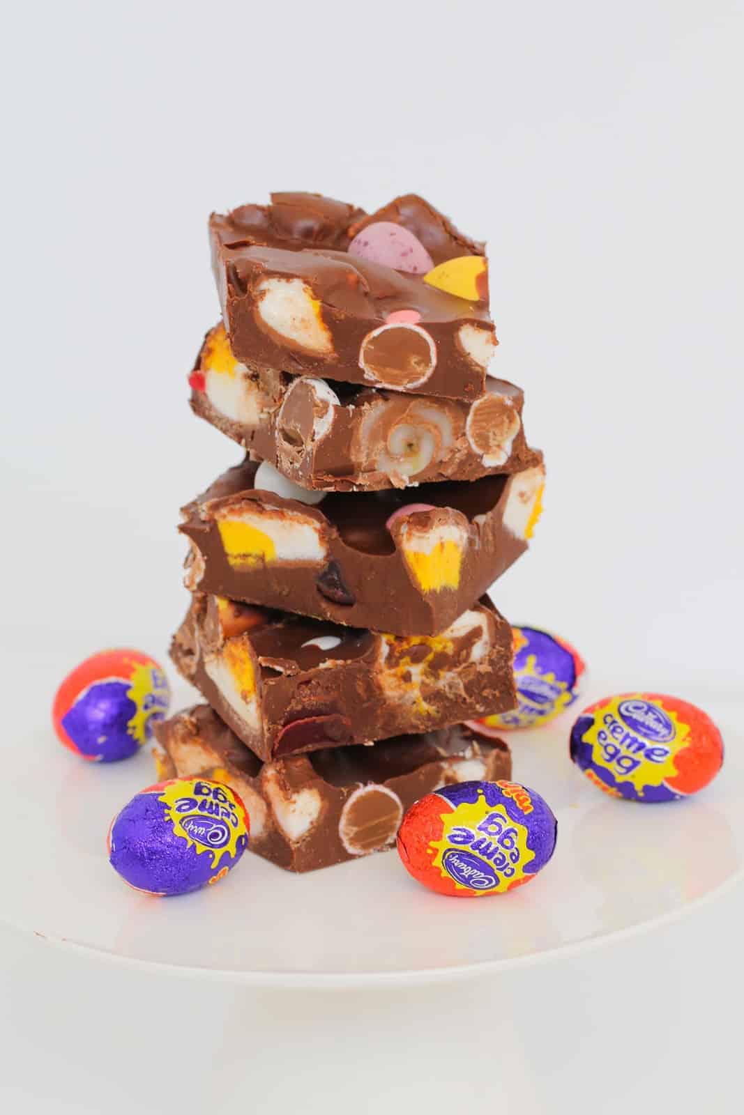 A stack of rocky road filled with chocolate Easter eggs, with Cadbury Creme Eggs around the base.