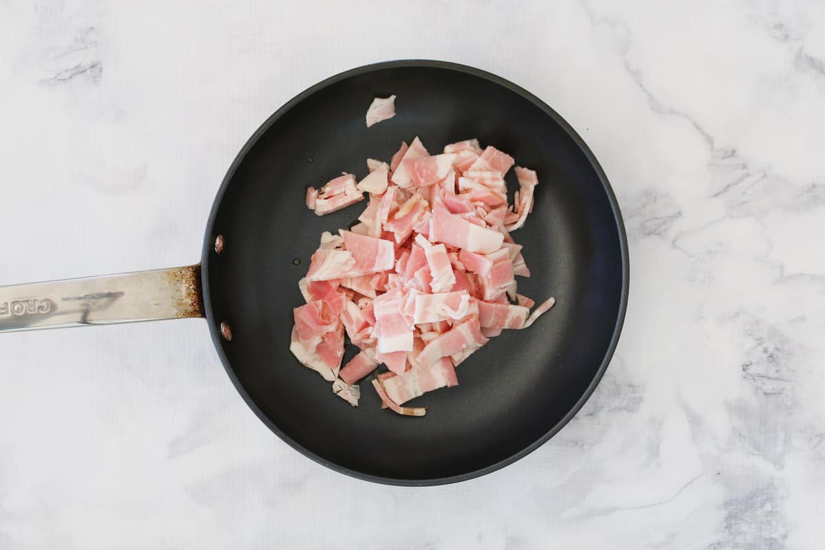 Bacon being cooked in a frying pan.
