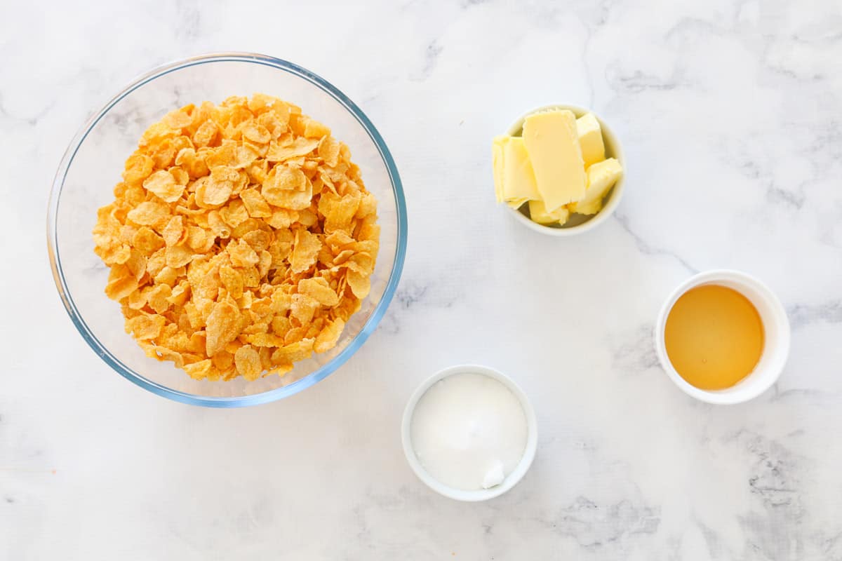The 4 ingredients in Honey Joys in bowls on  a marble bench.