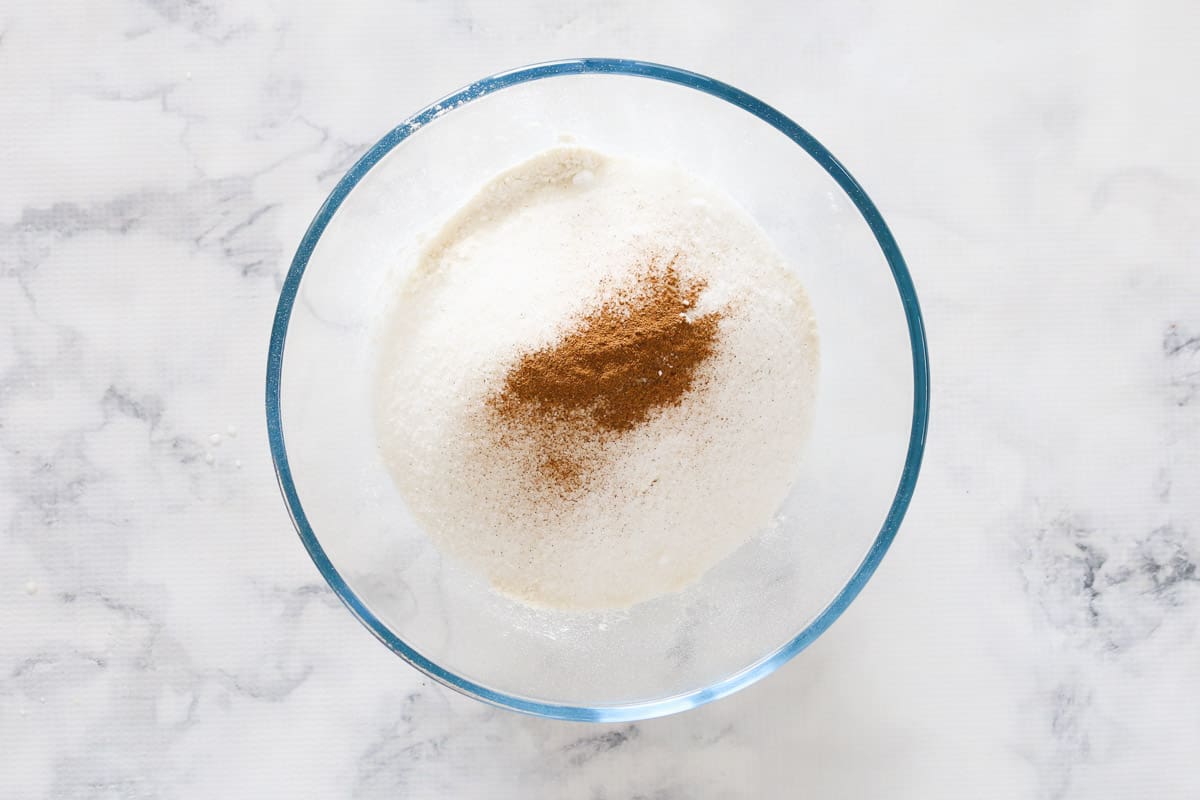 Sifted self raising flour and cinnamon in a clear glass bowl