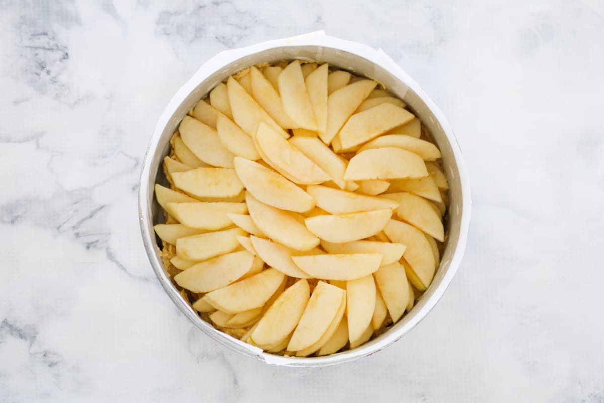 A layer of sliced apple placed over mixture in baking dish