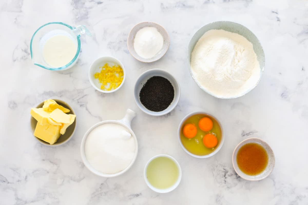 The ingredients for lemon poppy seed cake in individual bowls.