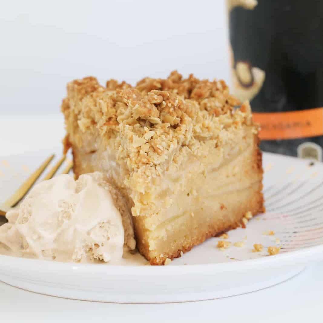A slice of apple crumble cake with a scoop of ice-cream on the side.