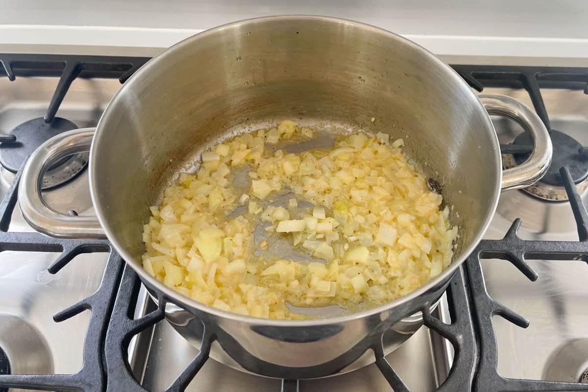 Diced onions and minced garlic sautéed until softened and translucent in a steel pot