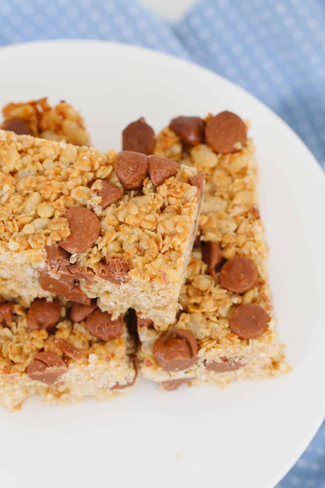 Muesli bars with chocolate chips stacked on top of each other on a white plate
