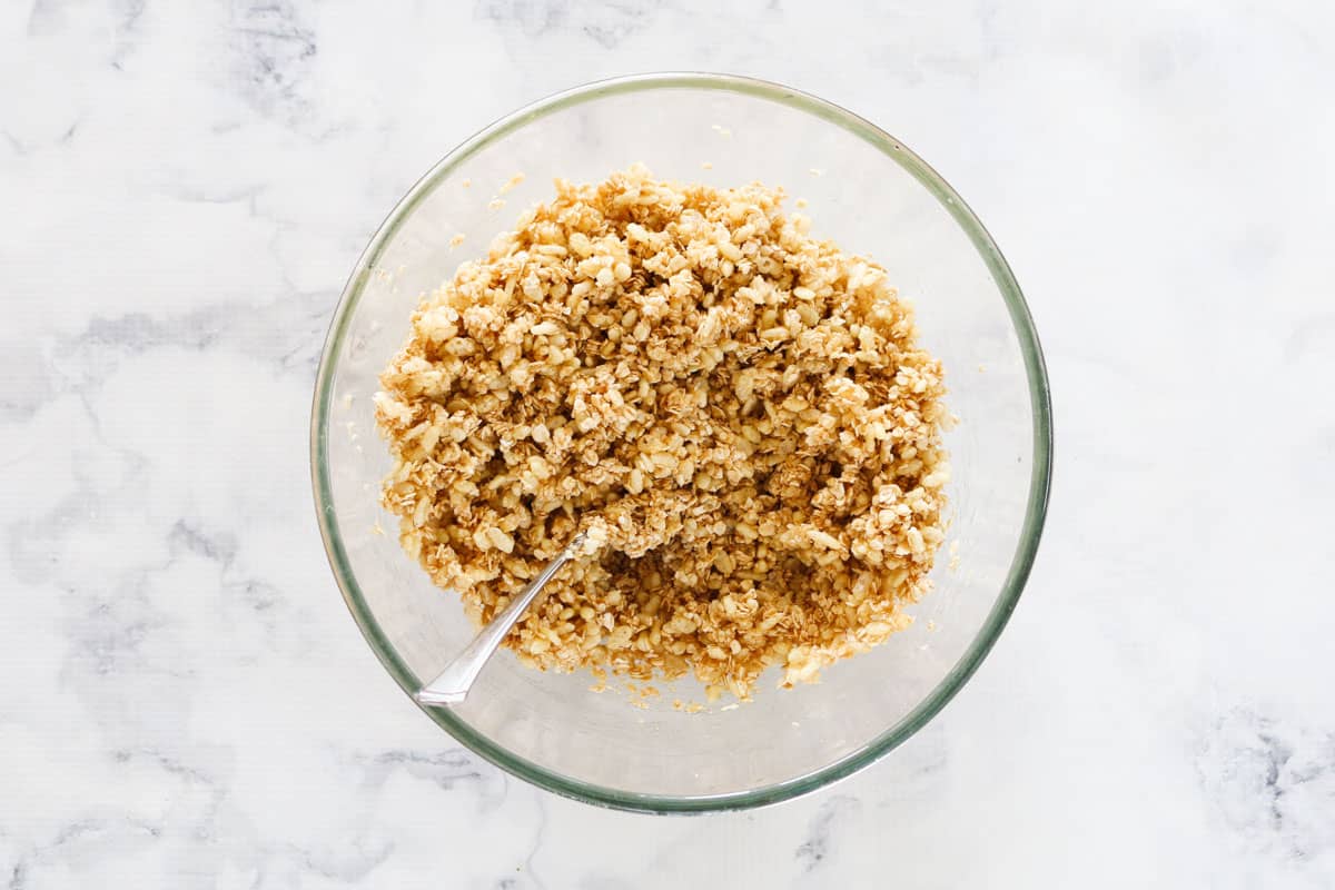 Quick oats and rice bubbles stirred into melted oil, sugar, honey and vanilla in a glass bowl