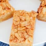 A close up view of a piece of honey almond slice on a white plate