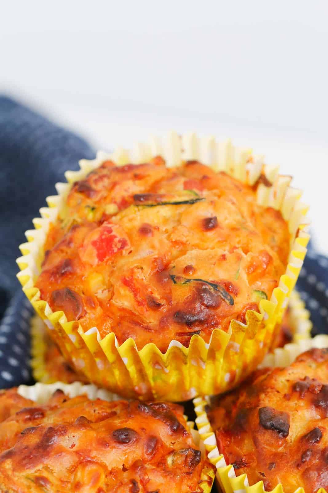 A close up of a vegetable savoury muffin in a yellow muffin case