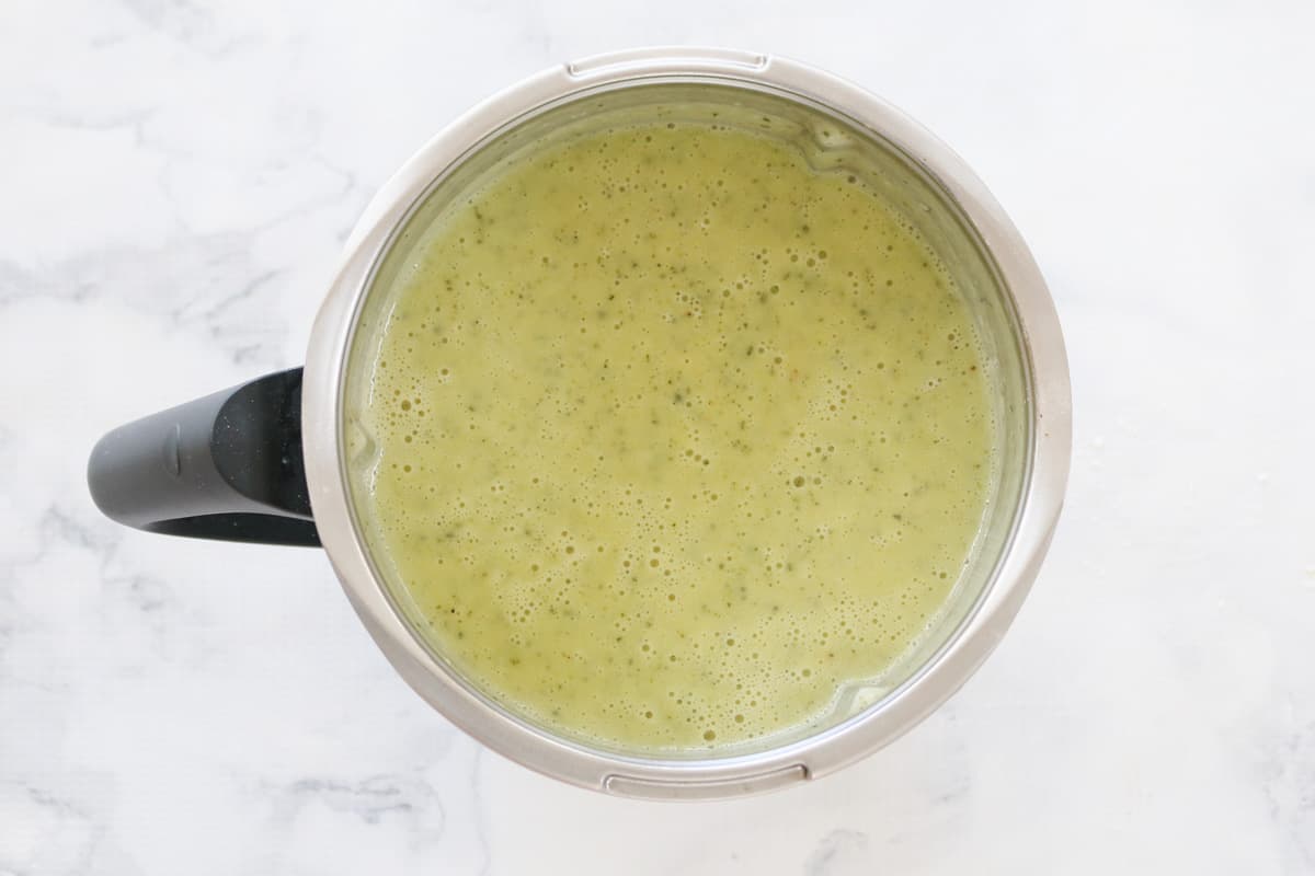 A blender filled with creamy zucchini soup