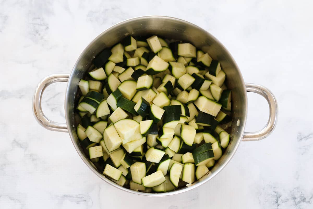 Cut up zucchinis in a double handled pot
