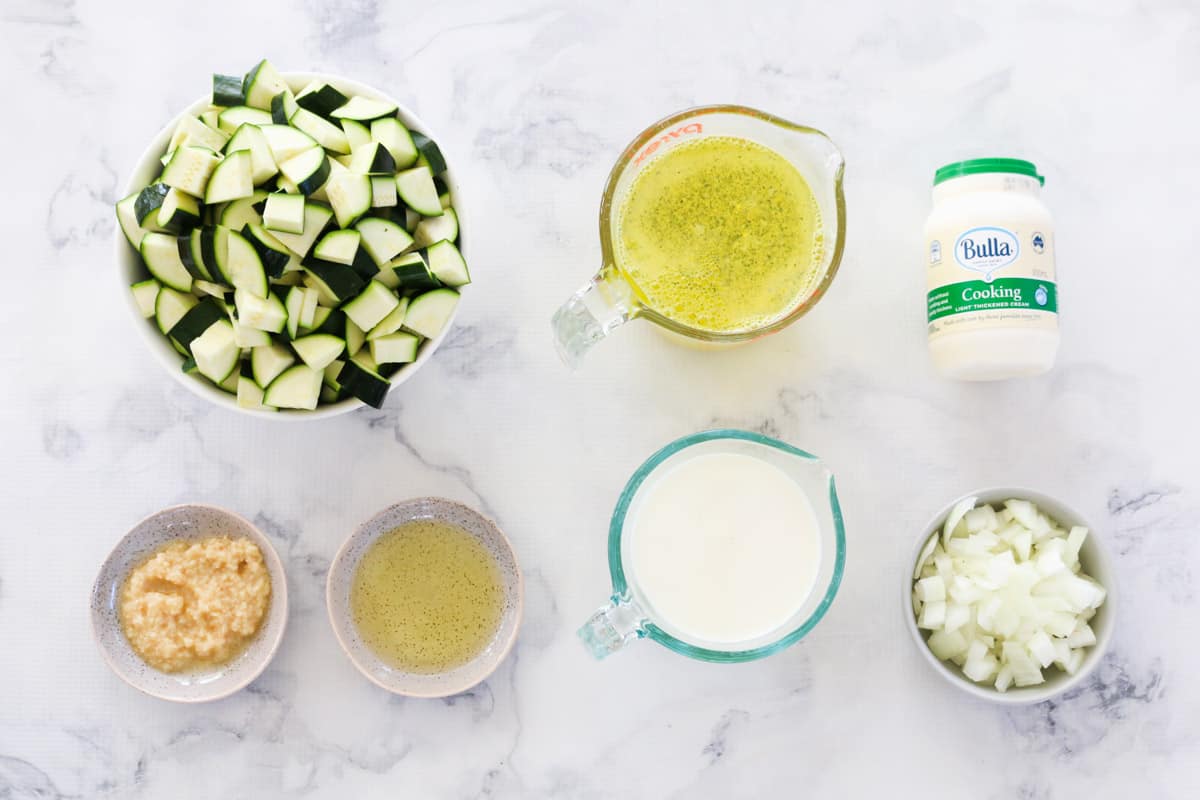 Ingredients for zucchini soup in individual bowls