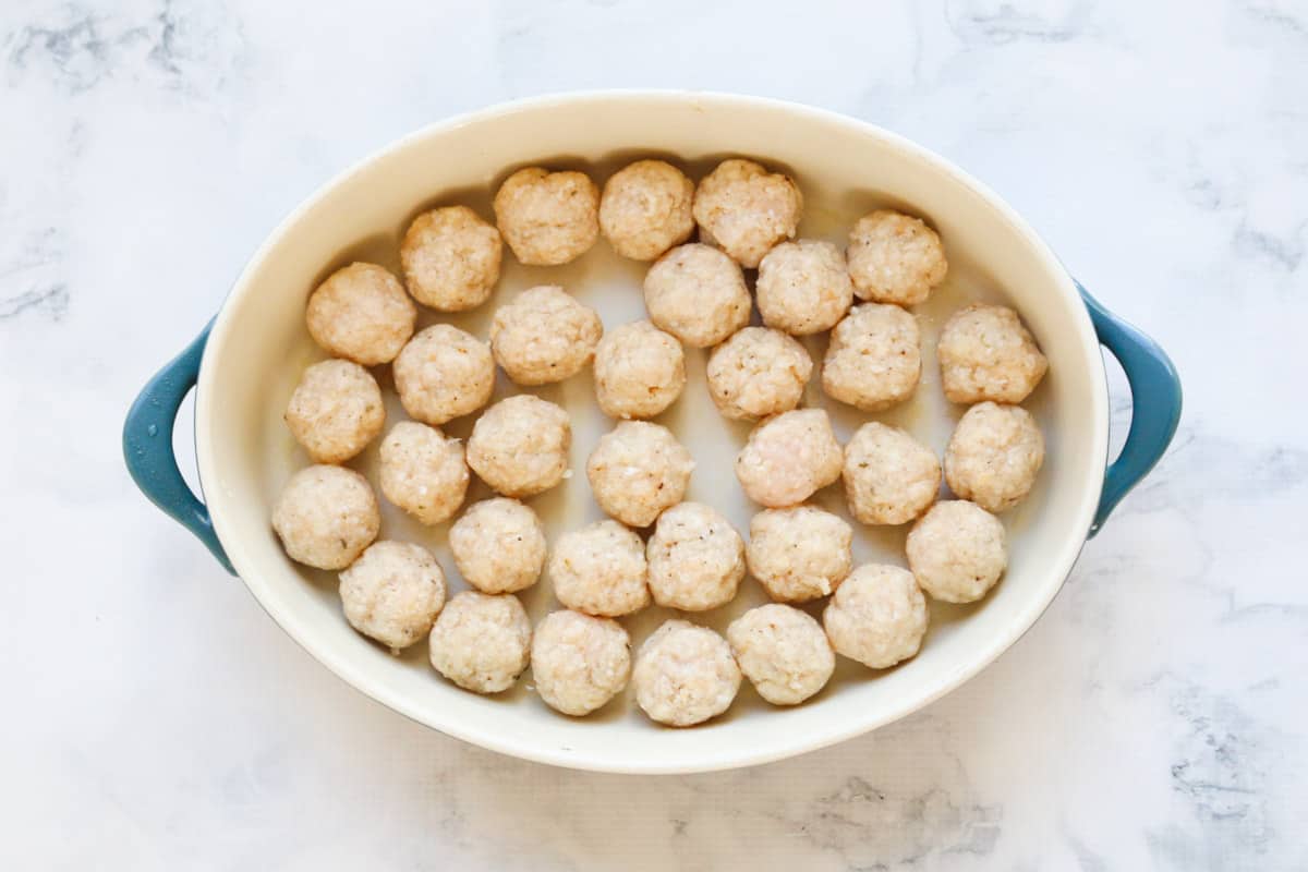 Chicken mince rolled into balls in a baking dish.