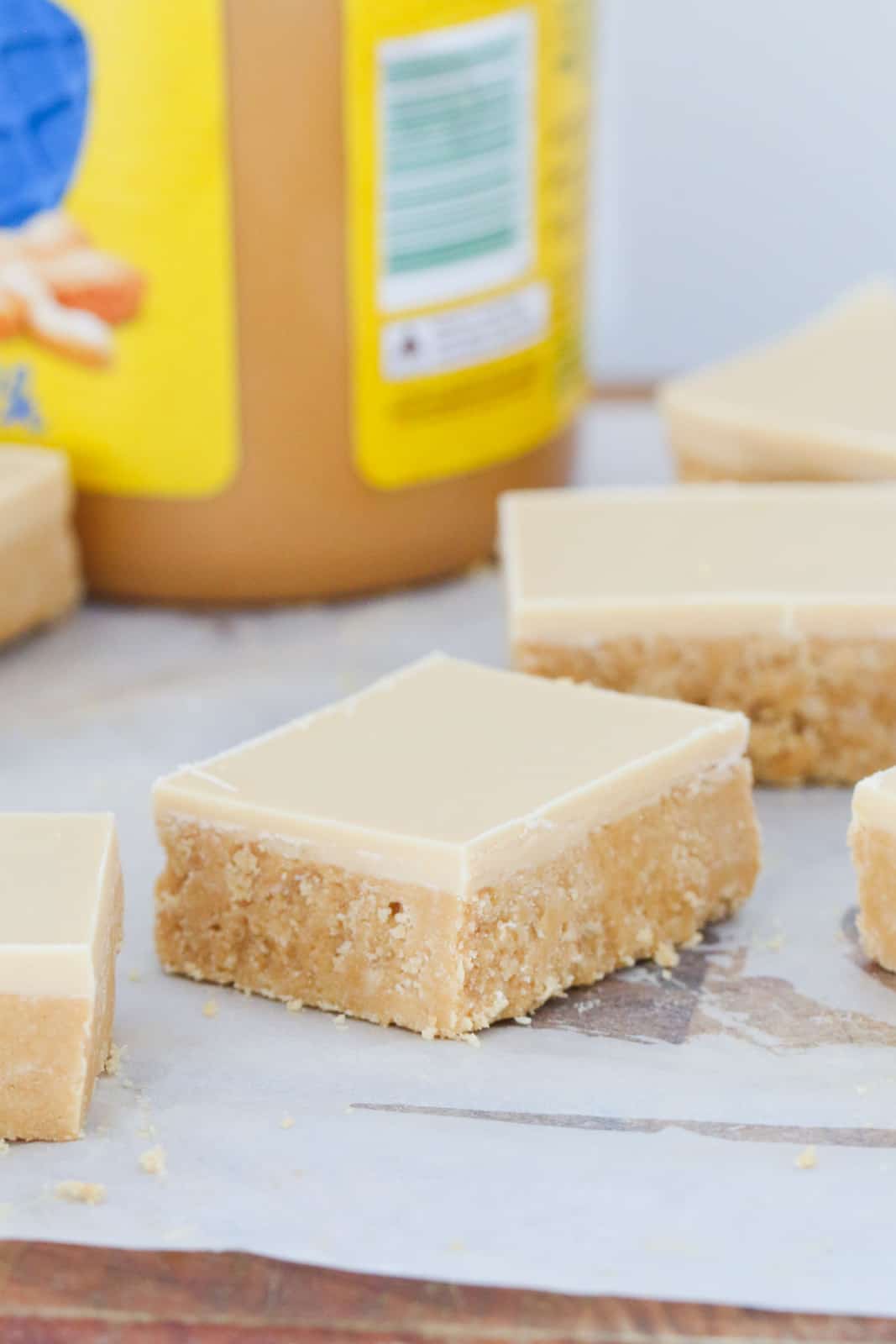 Squares of peanut butter slice topped with white chocolate and peanut butter topping.