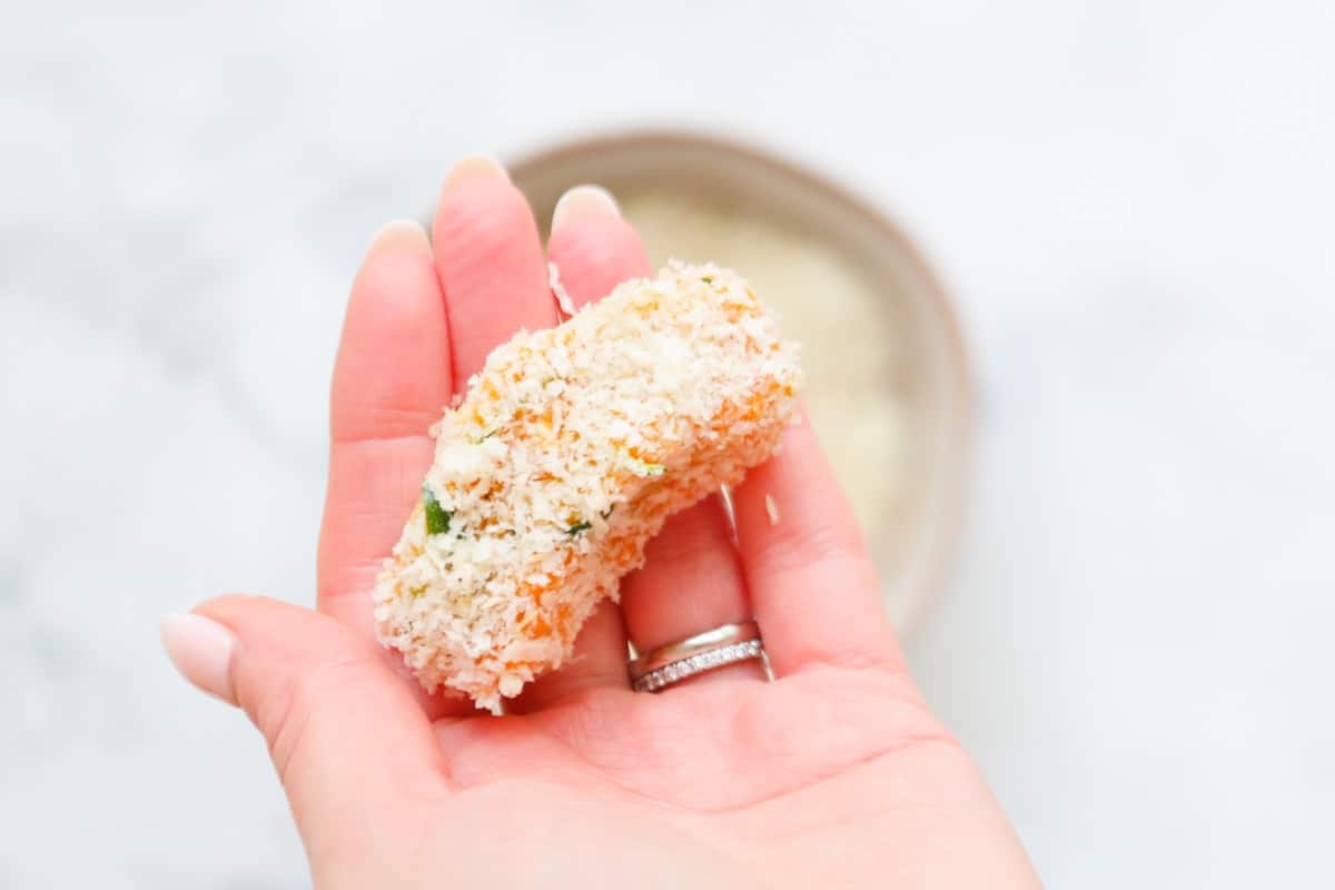 A Veggie Nugget shaped, crumbed and in the palm of a hand