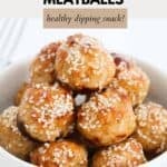 A small bowl filled with juicy baked Thai chicken meatballs, sprinkled with sesame seeds.