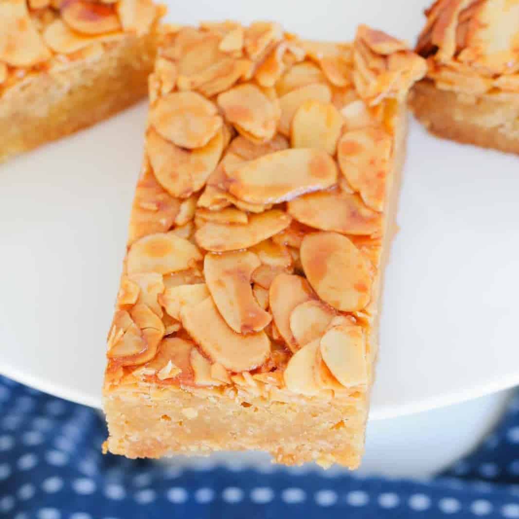 A close up view of a piece of honey almond slice on a white plate