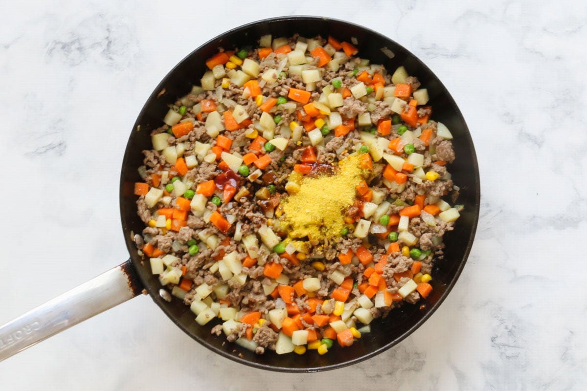 Mince and diced vegetables sauteéing in a frying pan with sauces and stock powder