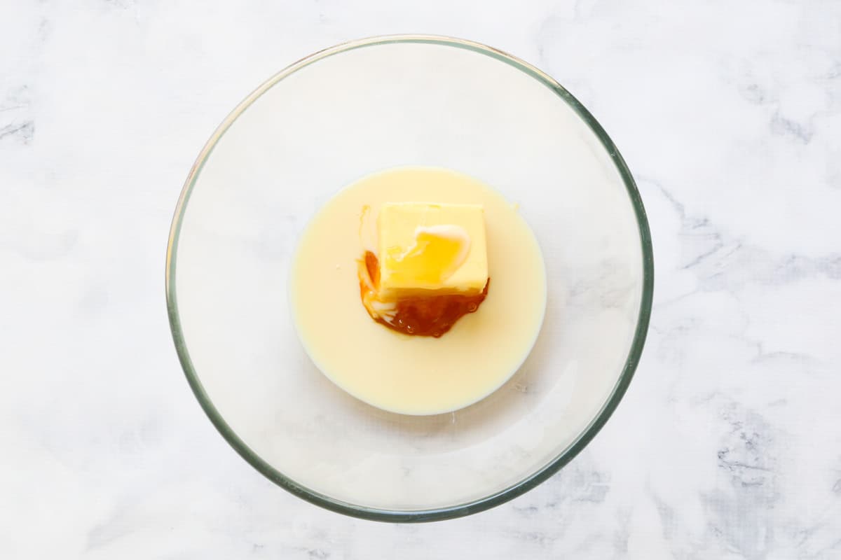 A glass bowl with butter, condensed milk and golden syrup in it