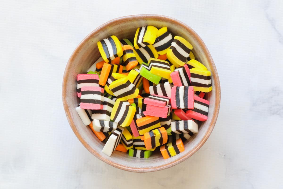 A bowl filled with licorice allsorts, sliced into pieces