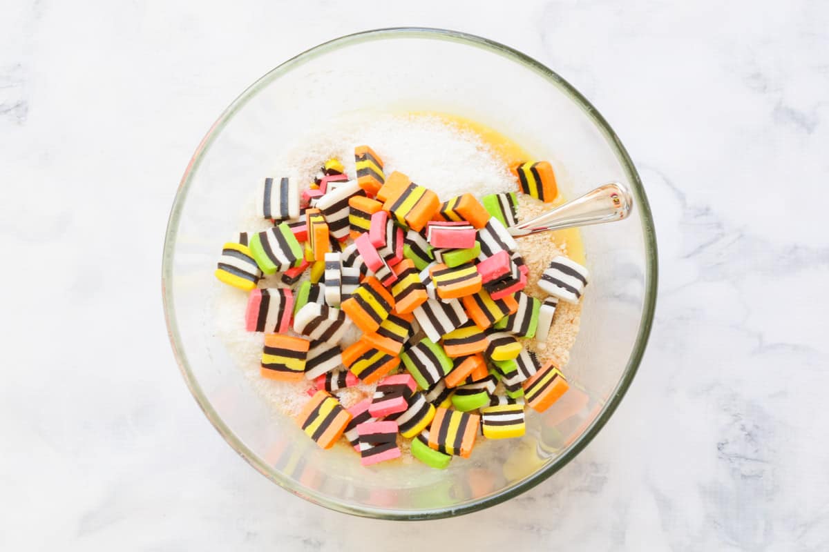 Biscuit crumbs, coconut, and chopped licorice allsorts in a glass bowl